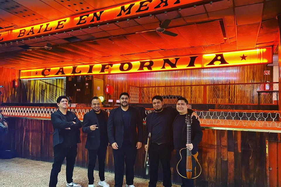 Grupo musical frente a un bar