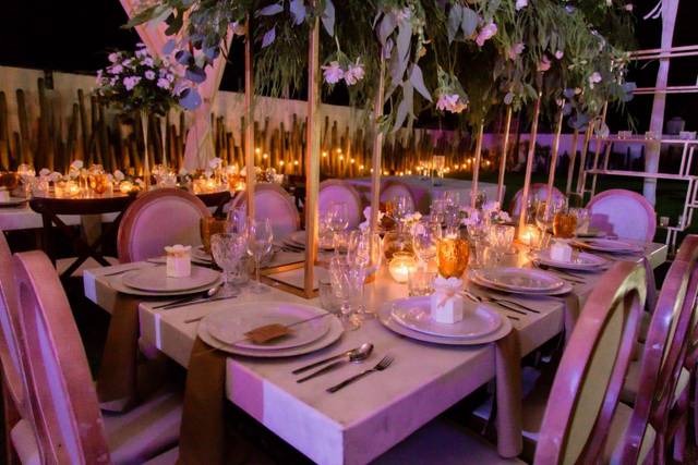 Mesa decorada con copas, velas y flores blancas