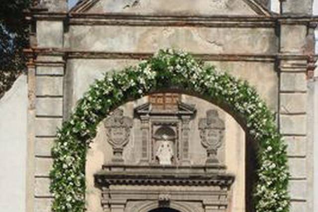 Arco de flores blancas en la entrada de la iglesia