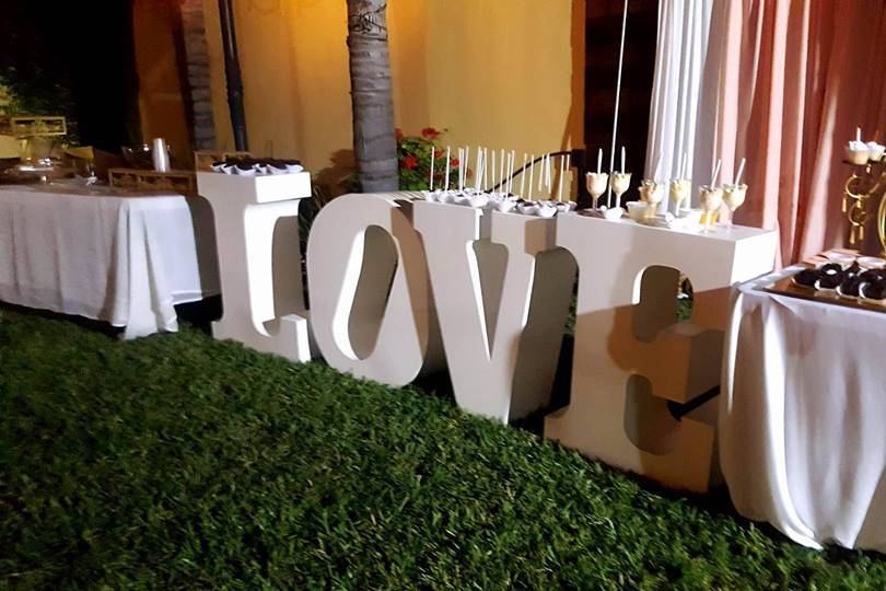 Letras gigantes blancas en el jardín