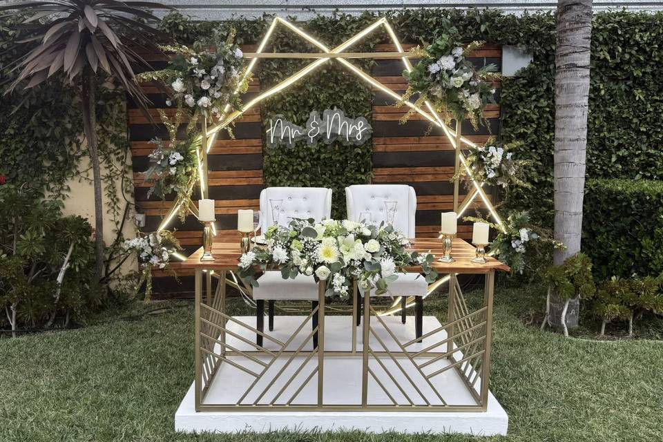 Mesa de novios decorada con flores blancas y velas
