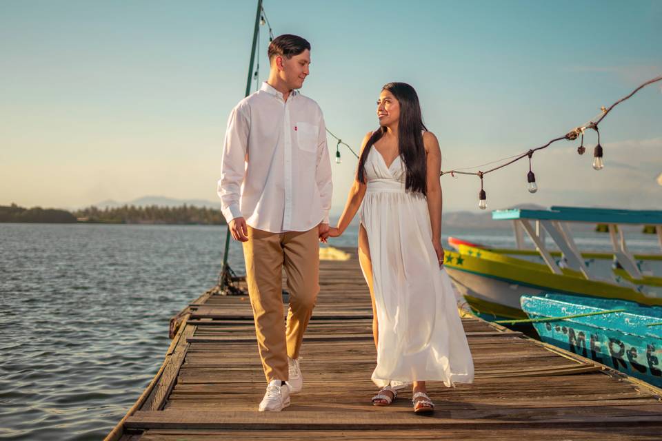 Pareja caminando de la mano por un muelle