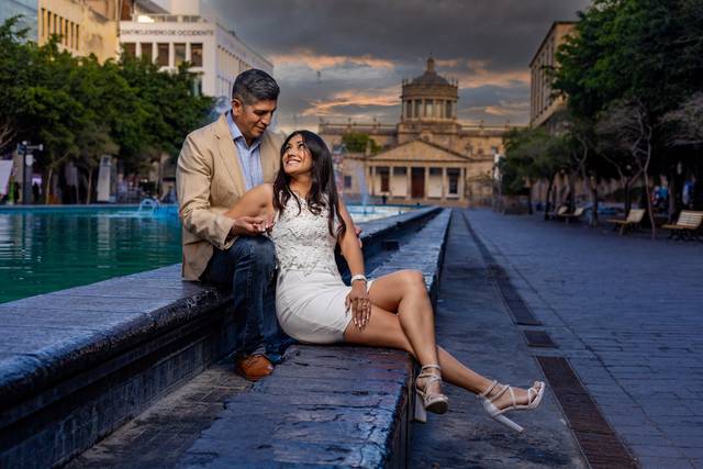 Pareja sentada a lado de una fuente