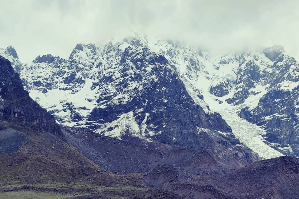 Mujer frente a un lago en las montañas