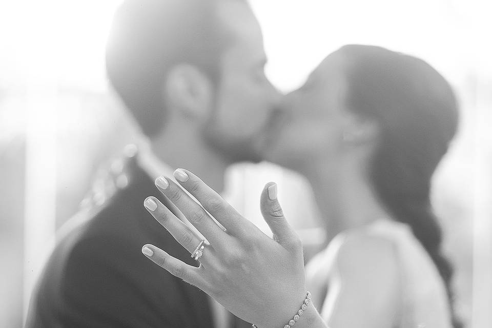 Novios besándose y novia enseñando el anillo