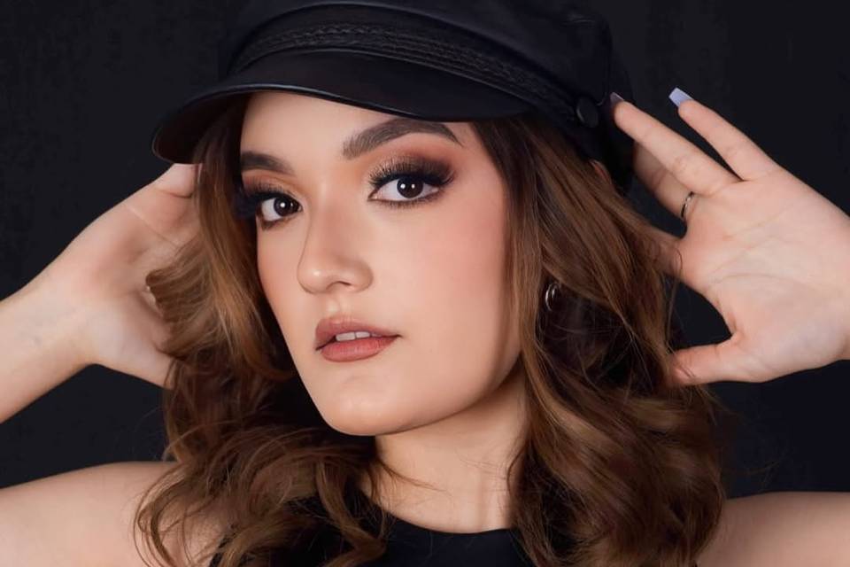 Mujer con make up glamouroso y gorra