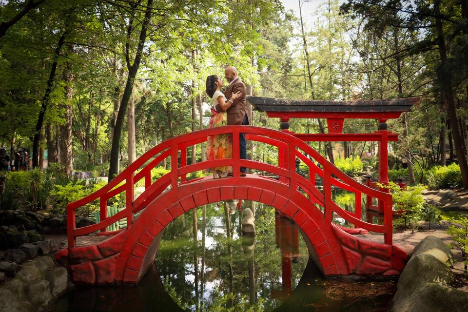 Pareja en un puente rojo en un jardín