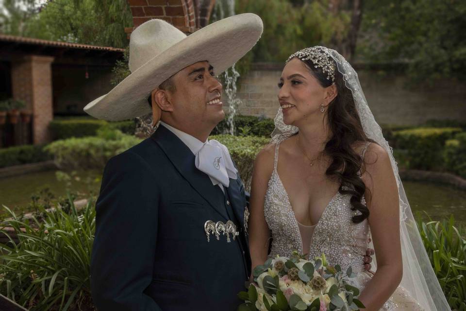 Novio vestido de charro y novia mirándolo