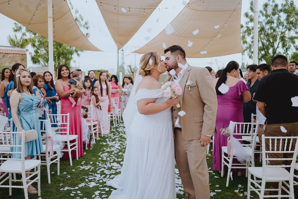 Novios besándose frente a los invitados