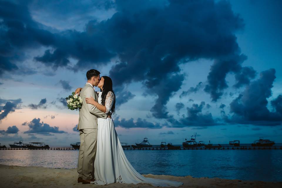 Novios besándose frente al mar