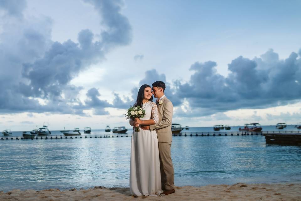 Novios abrazados frente al mar