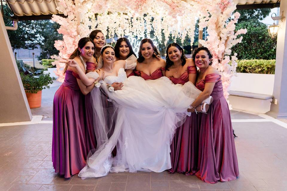 Damas de honor cargando a la novia