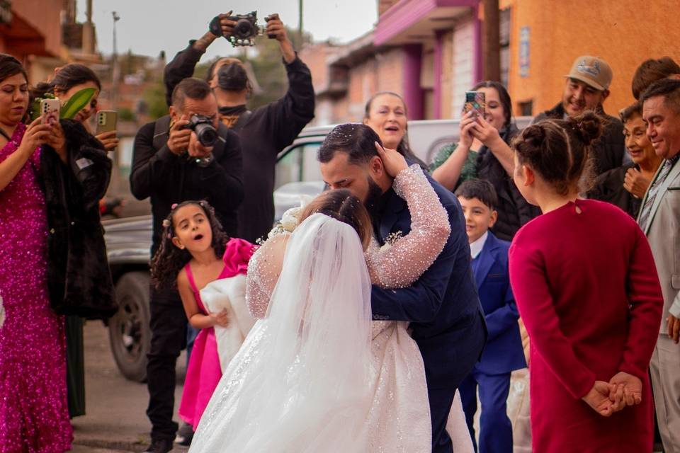 Novios besándose en medio de sus invitados