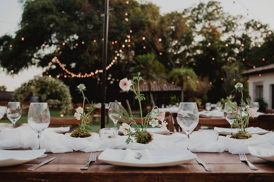 Mesa adornada con copas de cristal y flores
