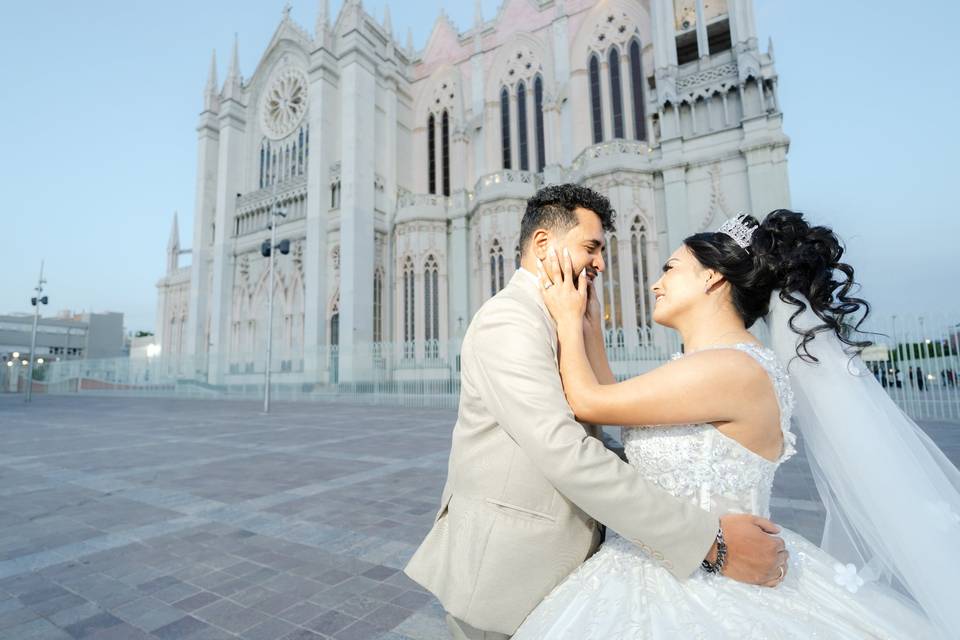 Novios tocándose la cara frente a una iglesia