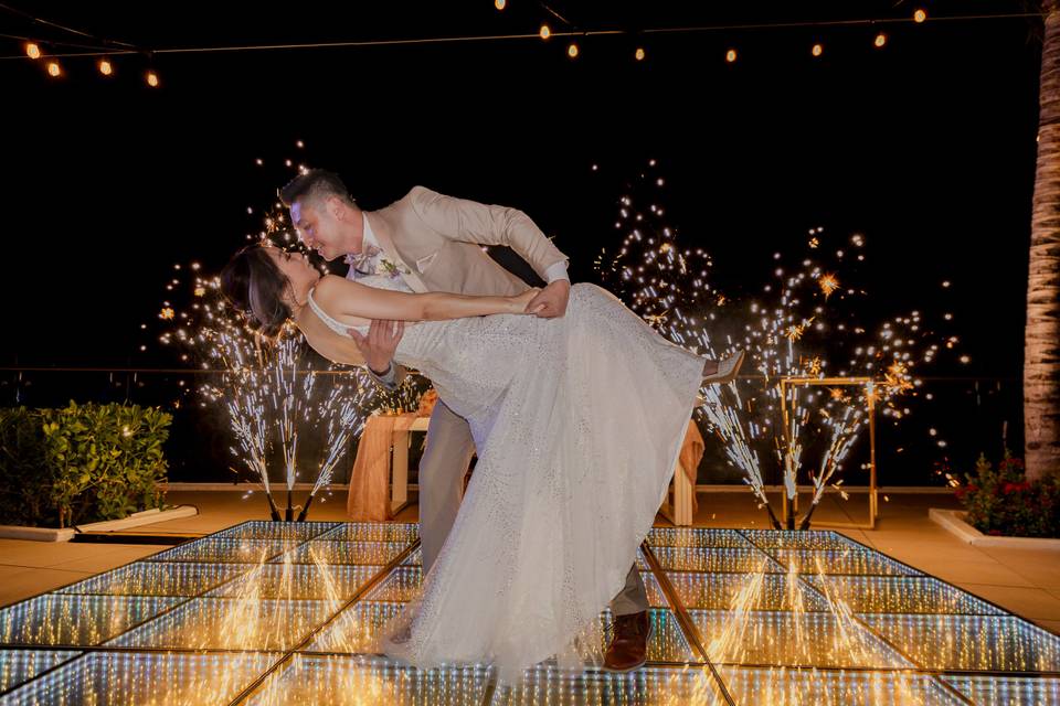 Recién casados bailando en la pista iluminado