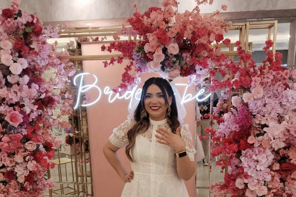 Novia frente a un letrero neón y flores