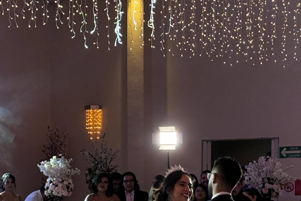 Novios bailando en medio de la pista con humo de hielo