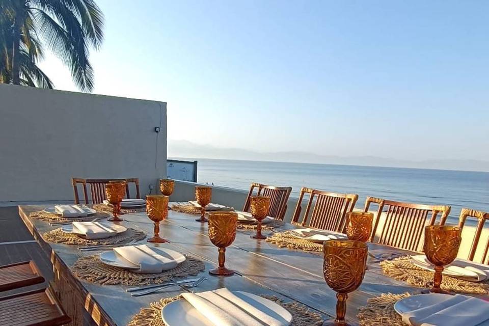 Mesa de madera decorada con platos blancos y copas café