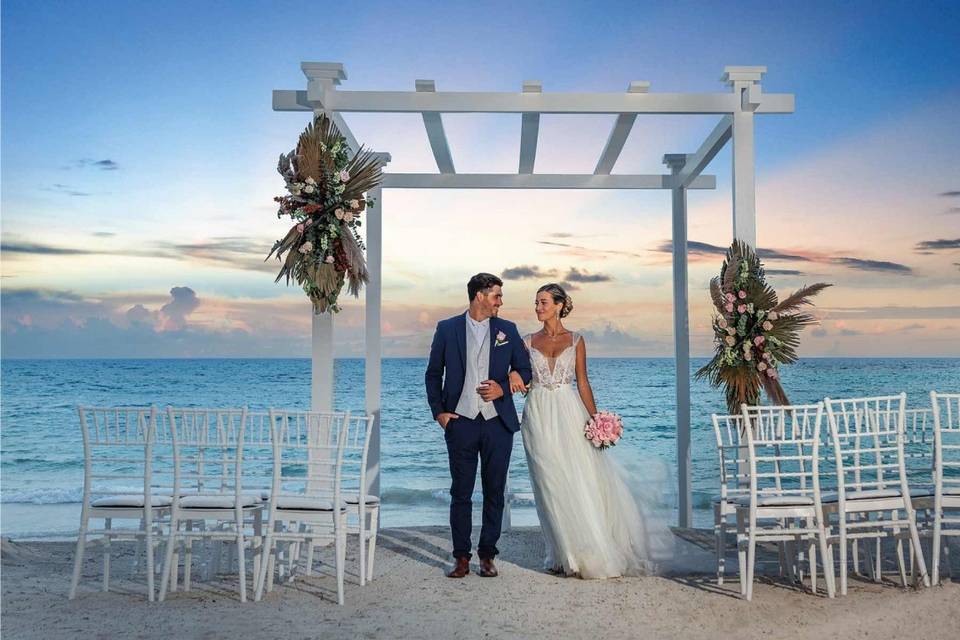 Pareja posando en el altar de matrimonio frente al mar