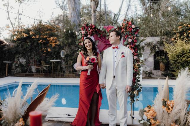 Recién casados posando en un jardín con alberca