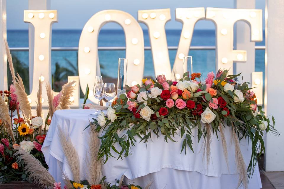 Mesa blanca con adorno de rosas de colores
