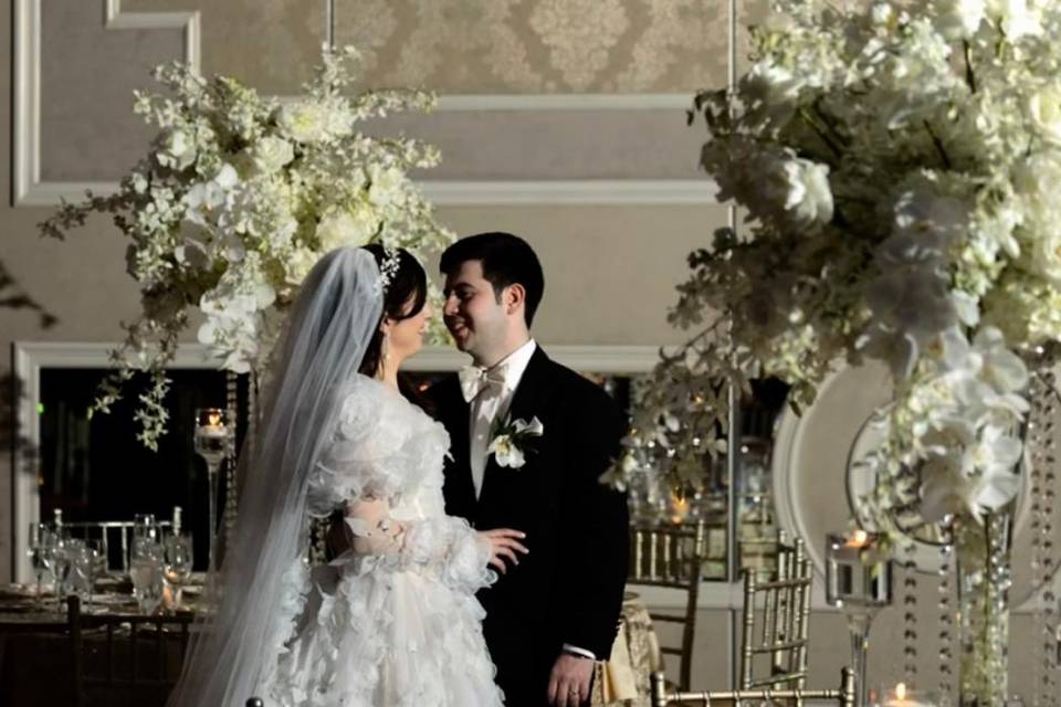 Novios posando en un salón decorado con flores