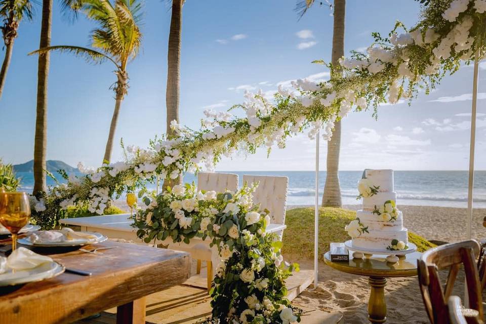 Mesa de novios decorada con flores blancas en la playa