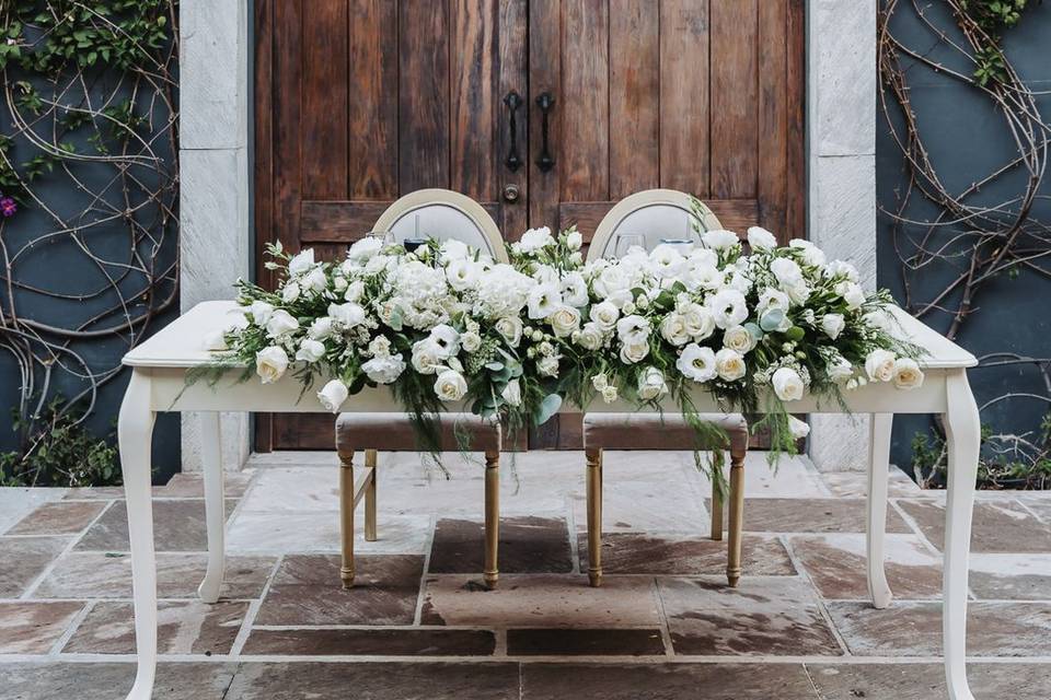 Mesa de novios decorada con flores blancas