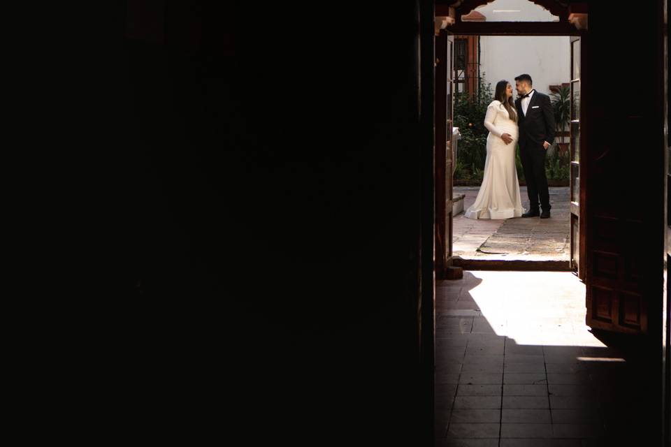 Novios en el patio vistos desde el interior de una casa