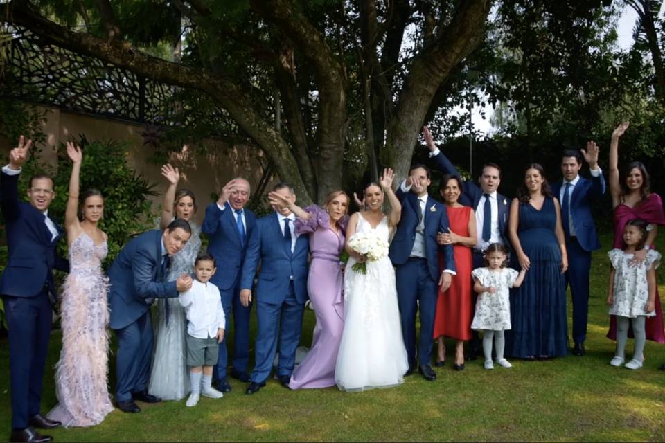 Novios posando con sus invitados en el jardín