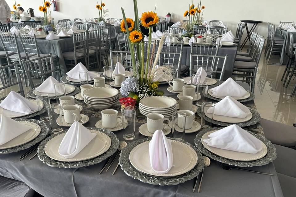 Mesa con mantel gris y vajilla blanca