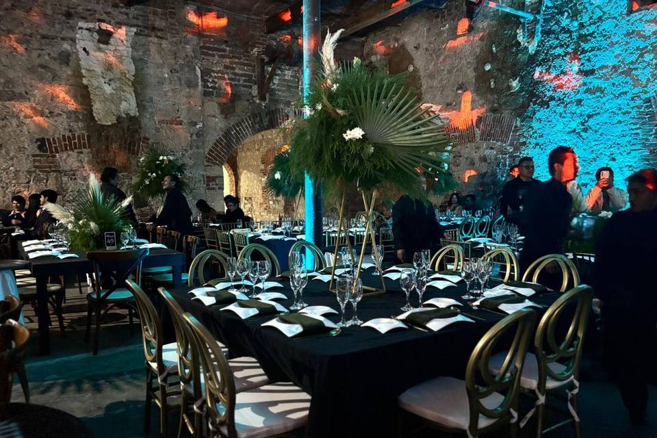 Mesas decoradas con manteles negros y flores en el centro