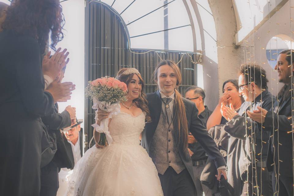 Novios caminando en medio de sus invitados