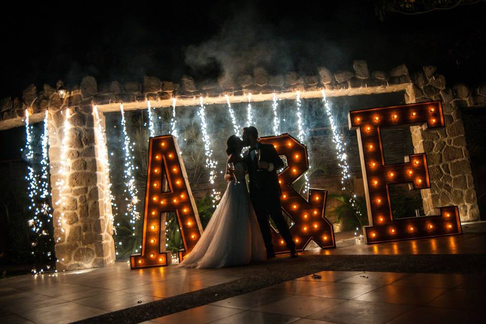 Novios dándose un beso frente a letras gigantes