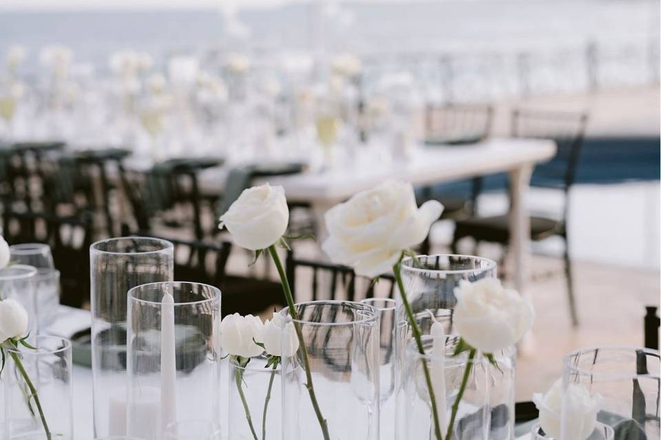 Decoración con vasos de cristal y flores blancas