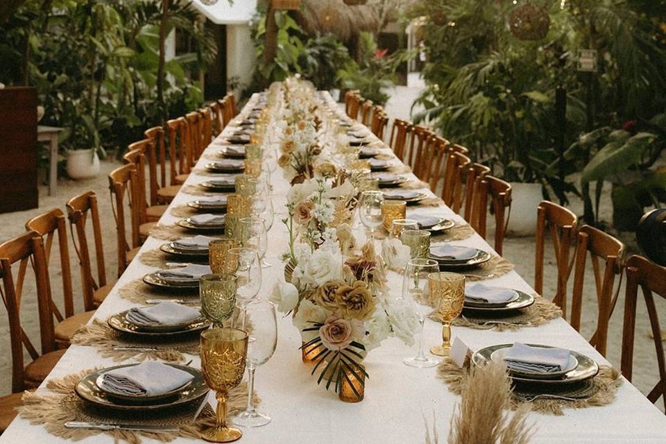 Mesa larga con sillas de madera y platos