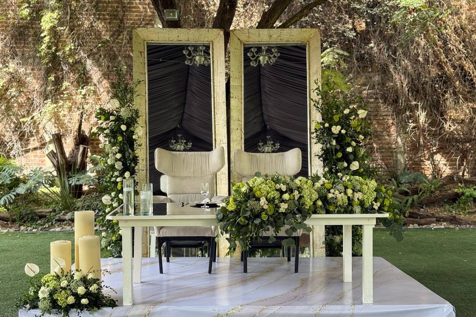 Mesa de novios decorado con velas gigantes y flores blancas