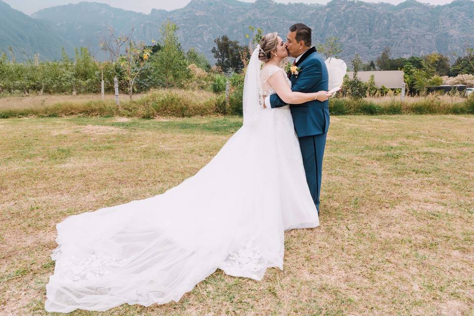 Novios dándose un beso en el campo