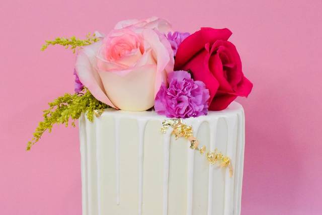 Pastel de un piso en color blanco con aplicaciones doradas y flores