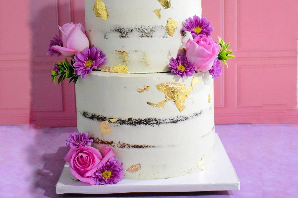 Naked cake con flores moradas y rosas