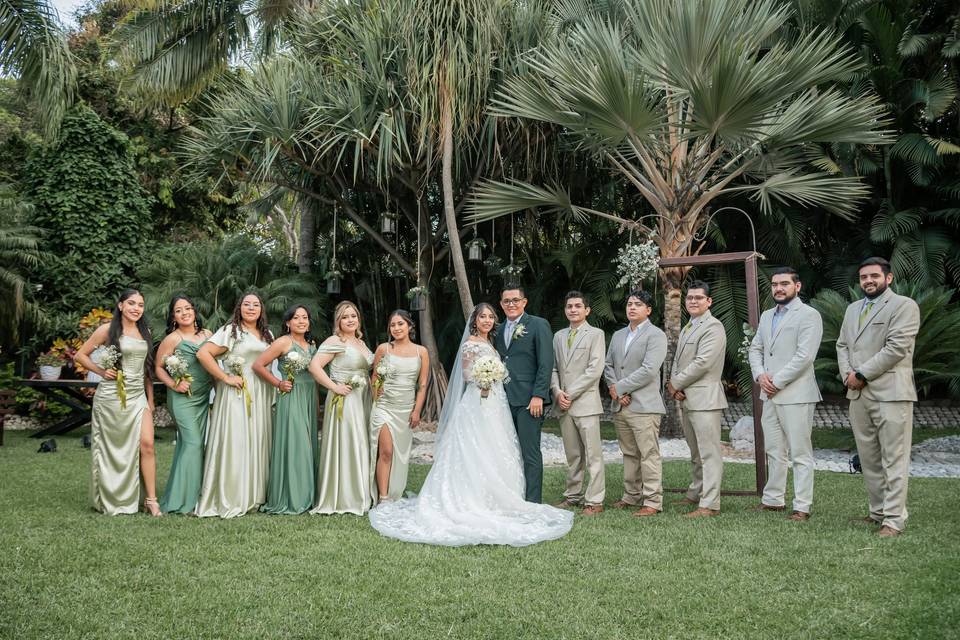 Novios posando con sus damas de honor y bestmen en el jardín