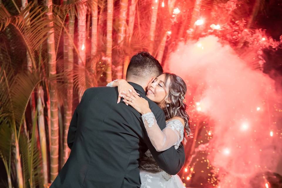 Novios bailando con fuegos artificiales