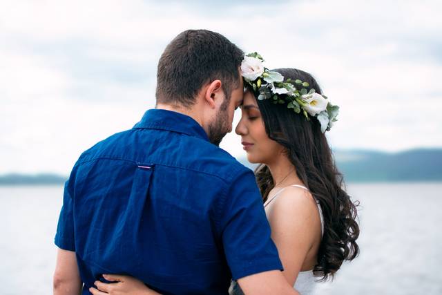 Novios abrazados frente a un lago