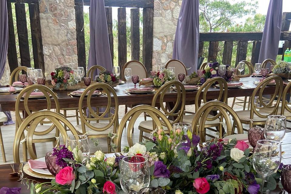 Centro de mesa con flores rosas y moradas