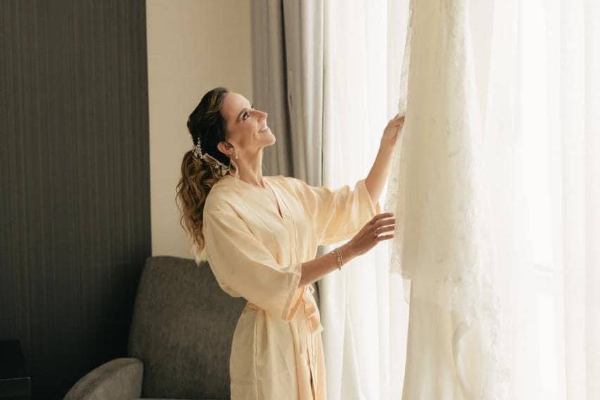 Novia viendo su vestido en la ventana