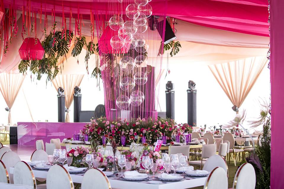 Montaje de sillas blancas con decoración rosa