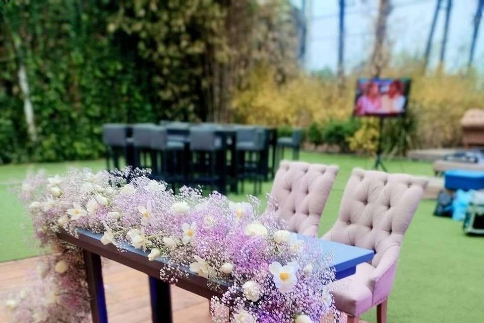 Mesa de novios con decoración floral lila