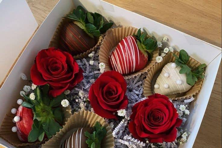 Fresas con chocolate y rosas en una caja