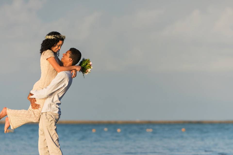 Novio cargando a la novia en la playa